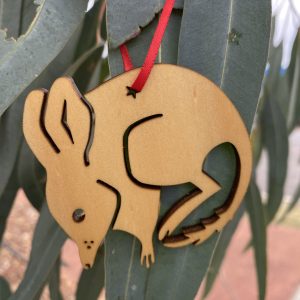 A Christmas bilby decoration hanging off an eucalyptus tree